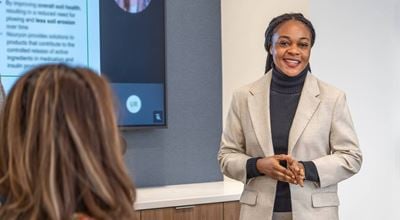 Woman in neat clothing in front of a presentation screen