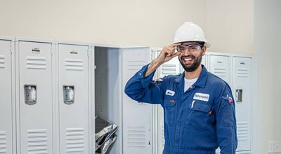 Nouryon Production Operator standing in front of white lockers