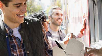 Couple enjoys their takeout food that is packaged in a bleached paperboard container