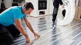 Man installing flexible tubes for underfloor heating