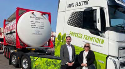 Two people standing in front of 100% electric truck